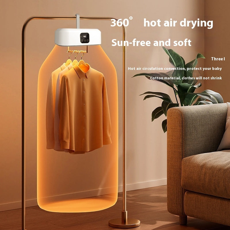 Hot air dryer with clothes inside, placed in a room with a sofa and plant.